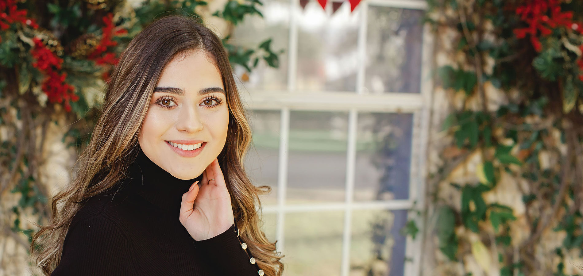 Woman smiling while posing with her hand on the side of her face | Frisco's Premier Orthodontics