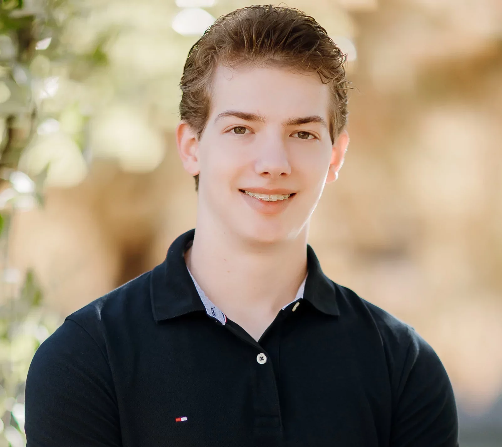 Blonde teen boy with clear braces smiling for photo | Frisco's Premier Orthodontics