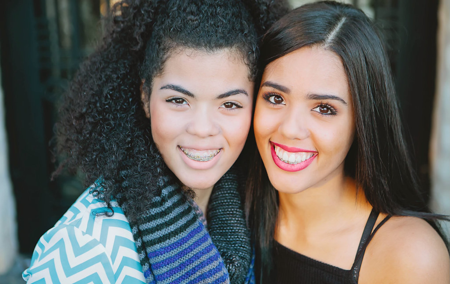 Girl with braces posing with girl with Invisalign® for photo | Frisco's Premier Orthodontics