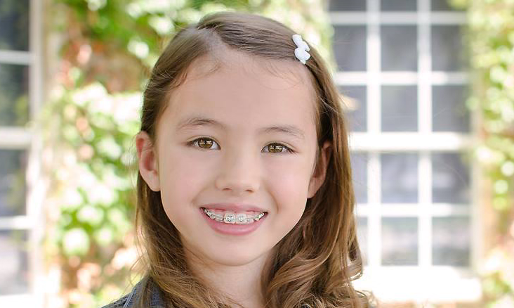 Young girl with braces smiling for photo | Frisco's Premier Orthodontics